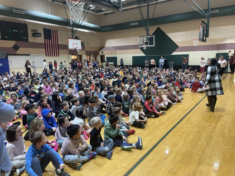 Group of people gathered in gymnasium for event.
