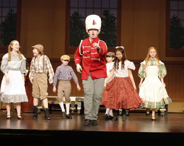 Theatrical performance of a marching band on stage.