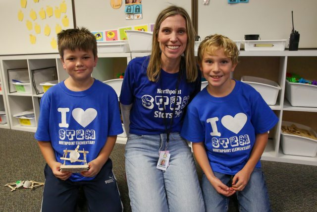 teacher with students wearing blue I love STEM t-shirts
