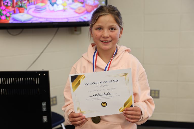 Girl in jacket holding certificate.