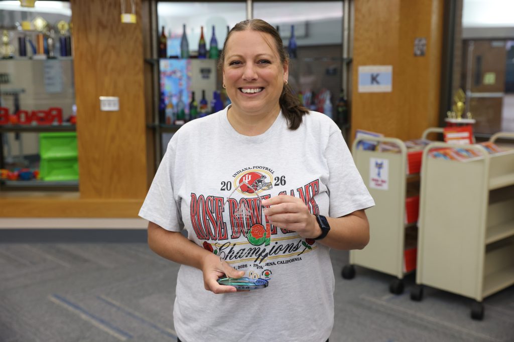 Woman in white shirt holding a trophy.