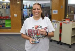 Woman in white shirt holding a trophy.