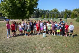a group of Northpoint elementary students standing outside in a field with two teachers